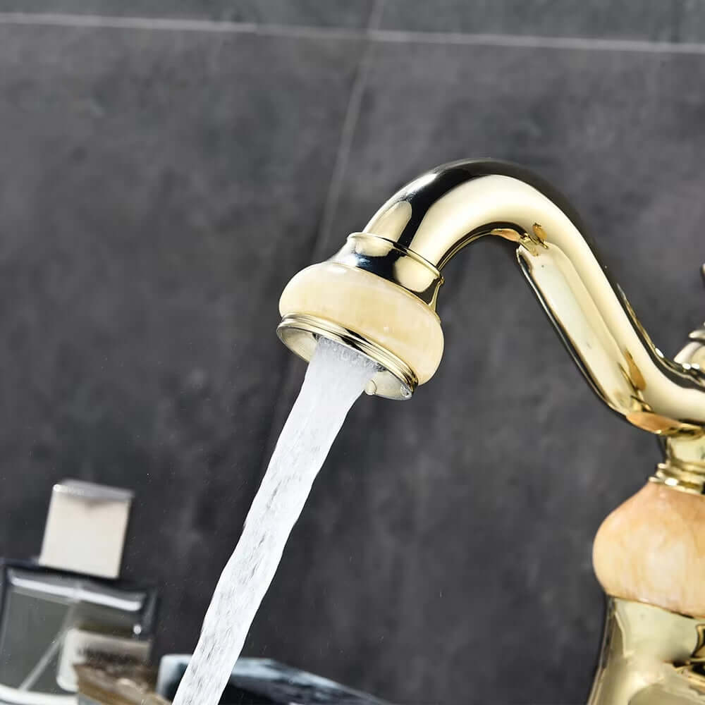 Luxury golden basin faucet with flowing water, showcasing a stylish modern design and polished finish.