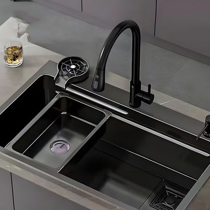 Black multifunctional stainless steel workstation kitchen sink installed on a kitchen countertop with faucet, cup washer, movable inner basin, drain area, and integrated accessory platform.