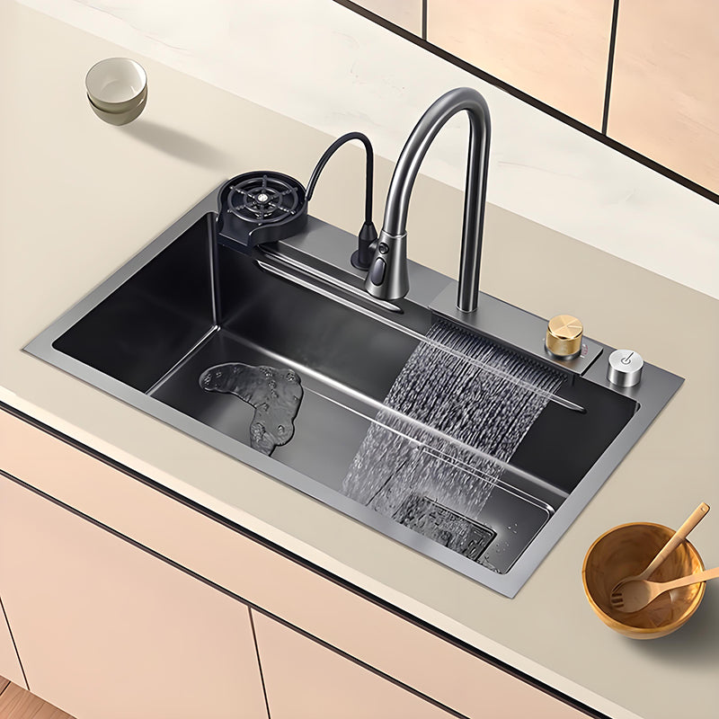 Gray and black waterfall multifunctional stainless steel workstation kitchen sink installed in a light countertop with high-arc faucet, cup washer, control knobs, and wide waterfall rinsing outlet.