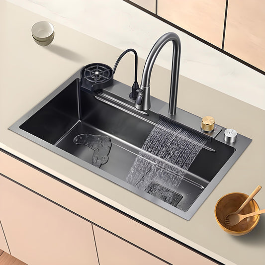 Gray and black waterfall multifunctional stainless steel workstation kitchen sink installed in a light countertop with high-arc faucet, cup washer, control knobs, and wide waterfall rinsing outlet.