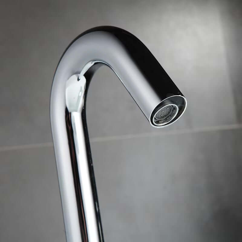 Close-up of a sleek, modern countertop-mounted sink faucet with automatic sensor technology.