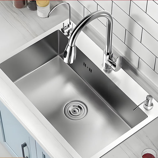 Natural stainless steel single bowl kitchen sink installed in a white countertop with high-arc faucet, auxiliary faucet, soap dispenser, brushed bowl surface, and round drain cover.