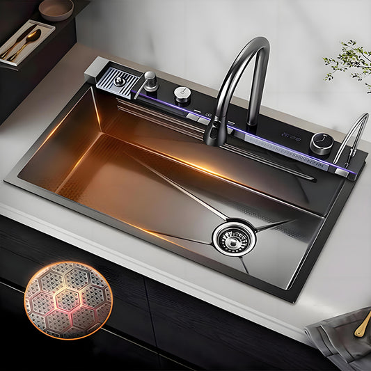 Smart stainless steel workstation kitchen sink installed in a modern countertop, featuring a large single bowl, high-arc faucet, linear waterfall outlet, rear control panel, and illuminated sink interior detail.